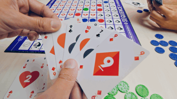Mensen die het strategische bordspel Sequence spelen