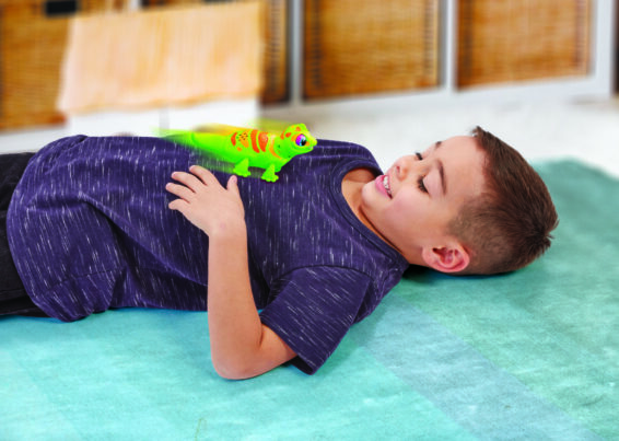 Een kind met de Let's Go Gecko op zijn buik