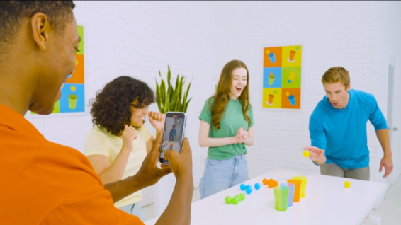 Een groep mensen wat het partyspel Pong Party speelt