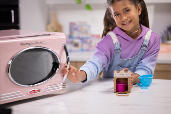 Een kind dat een cakeje in de magnetron gaat bereiden